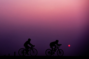 Naklejka na ściany i meble ride bicycle with sunset background.
