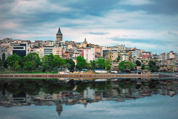 Fototapeta na wymiar View of the coast of Istanbul with the Galata Tower reflecting in water, Turkey