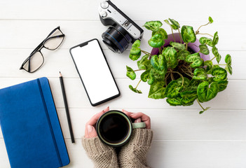 Top view of girl holding coffee mug at working place composition