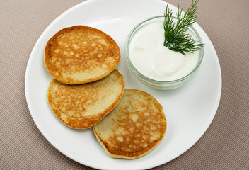 pancakes with sour cream in a white plate