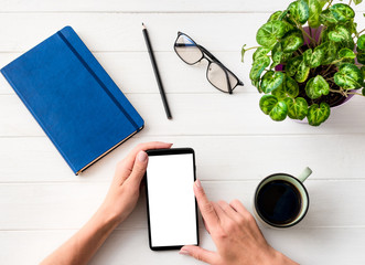 Top view of girl using smartphone at working place composition background