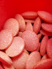 Pills in red container, macro / extreme closeup