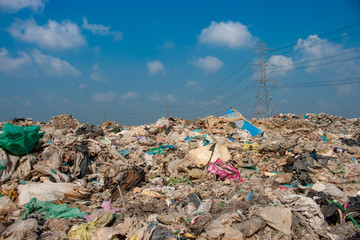 large pile of garbagewith blue sky and high voltage pole background