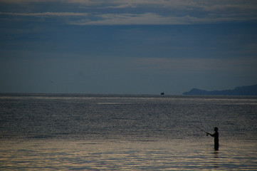 Fototapeta na wymiar 暗い海の釣り人