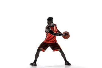 Fotobehang Full length portrait of a basketball player with a ball isolated on white studio background. advertising concept. Fit african anerican athlete with ball. Motion, activity, movement concepts. © master1305