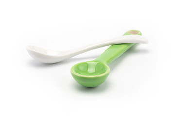Two cutie spoons green and white on white baceground