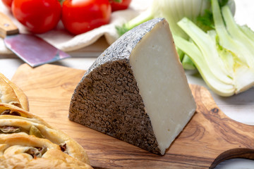 Italian cheese, piece of mature Tuscan Pecorino sheep cheese served with olive bread and tomatoes