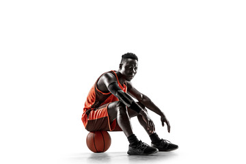 Full length portrait of a basketball player with a ball isolated on white studio background....