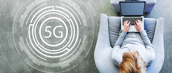 5G network with man using a laptop in a modern gray chair