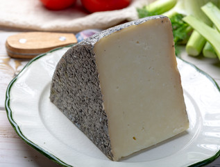 Italian cheese, piece of mature Tuscan Pecorino sheep cheese served with olive bread and tomatoes