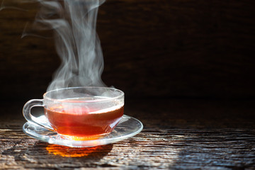 Hot tea cup in a glass on wood background.Hot drink . Copy space.