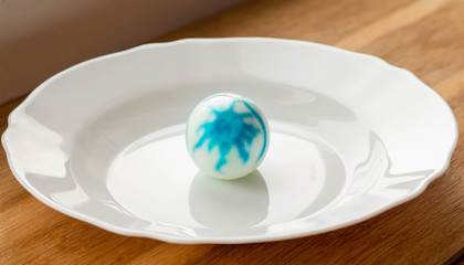 peeled dyed easter egg with traces of dye on egg white among other easter eggs, food dye safety
