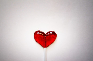 red heart shaped Lollipop on light background