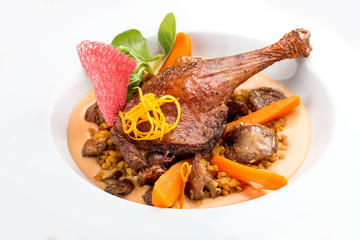 Duck leg with lentils and mushrooms on a white background