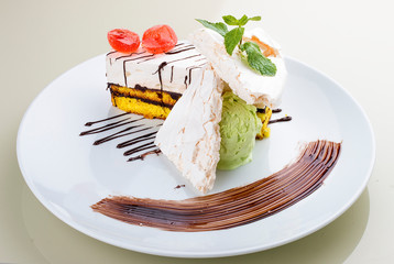 Dessert with meringue and ice cream on a white plate