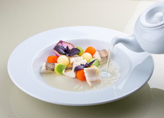 Fish soup with vegetables in the original serving