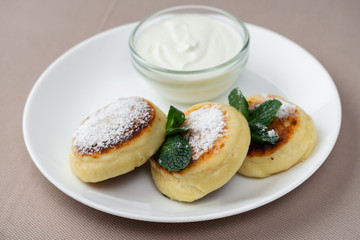 Fototapeta na wymiar pancakes with powdered sugar and sour cream