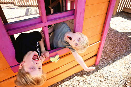 Two Cute Little Kids Playing Outside in a Club House at a Playground, Making Funny Faces