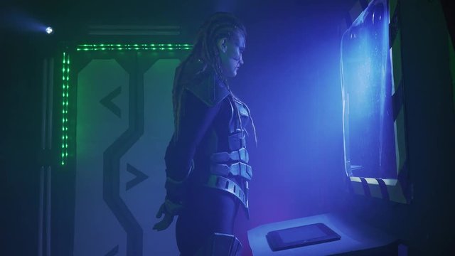 An alien invader in the spaceship is looking at the screen on the wall, 4k