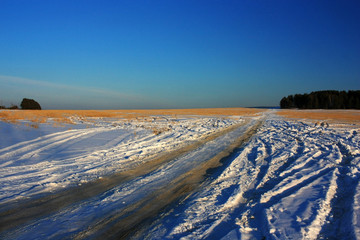 Dirt country road in a snowy field