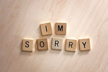 Words I'm Sorry Spelled out in Wooden Letter Blocks on Wood Background.
