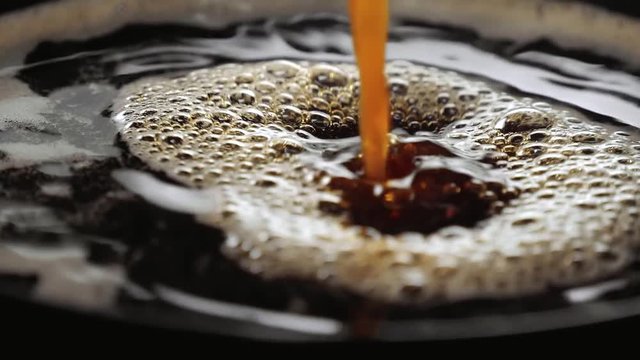 Close up shot of fresh coffee in a cup in slow motion