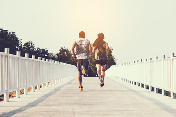 young couple runner running on running road in city park