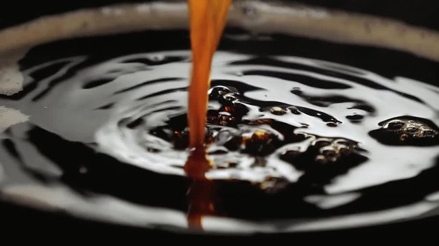 Close up shot of fresh coffee in a cup in slow motion