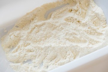 Plastic tray with flour for wrapping cuttings.