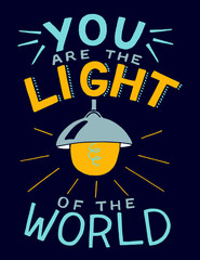 Hand lettering with bible verse You are the light of the world, made with glowing light bulb.