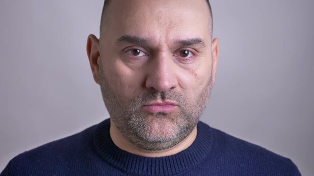 Closeup shoot of middle-aged caucasian man looking straight at camera with neutral facial expression