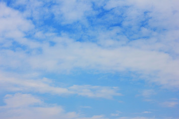 Empty blue sky background of simple cloudy texture. Template of sky with small clouds, plain backdrop of bright light blue color. Blank wallpaper or poster with copy space