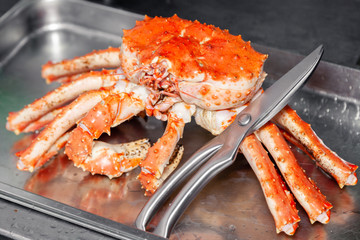 Carving fresh red big boiled prepared blue kamchatka crab with scissors. Concept useful seafood in menu, chef premium restaurant preparing crab for serving for guests, clients