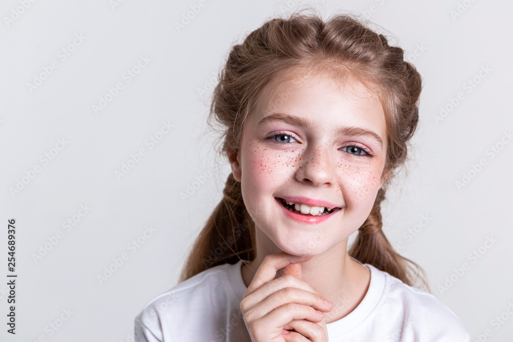 Wall mural contented little pretty kid showing her teeth in wide smile