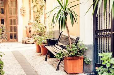 Bench and plants in tubs in the courtyard of the house in Catania, Sicily, Italy.