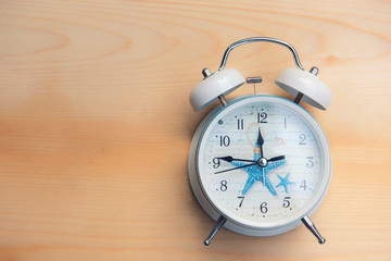 white alarm clock on a brown wooden background,