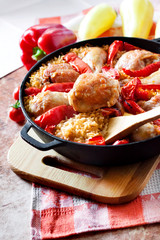Chicken thighs and legs baked over a bed of rice and red bell pepper