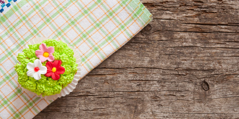 Cupcakes decorated with flowers for springtime wooden background