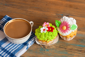 flower spring cupcake  with hot coffee cup on wooden table