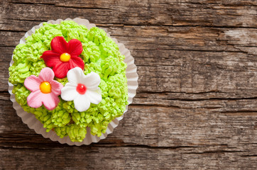 Cupcakes decorated with flowers for springtime wooden background