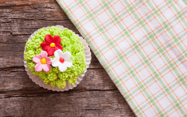 Cupcakes decorated with flowers for springtime wooden background