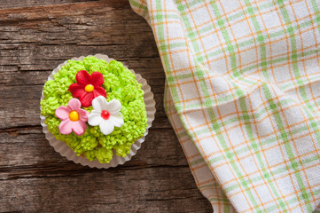 Cupcakes decorated with flowers for springtime wooden background