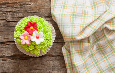 Cupcakes decorated with flowers for springtime wooden background