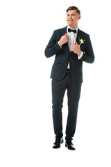 happy bridegroom in elegant black suit with boutonniere isolated on white