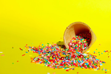 Abstract Colorful Background. Multicolored Candy Sweets On Yellow Background. Closeup Of Multicolored Small Candies. Candy In Ice Cream Cone.Minimal Art Design.