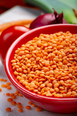 Dried orange lentils legume in red bowl