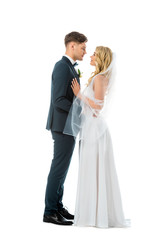 beautiful bride in long wedding dress and handsome groom in elegant suit standing face to face...