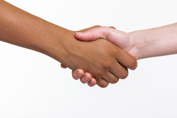 Pale and bronzed childish hands connecting in positive gesture
