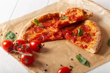 Pepperoni pizza with salami and cheese on a rustic table