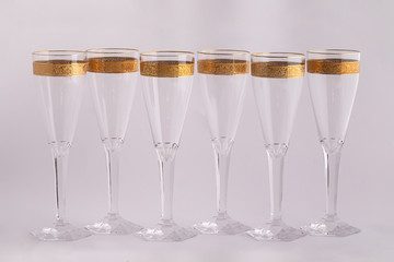 Champagne glasses made of Czech glass with a Golden ornament isolated on a white background.